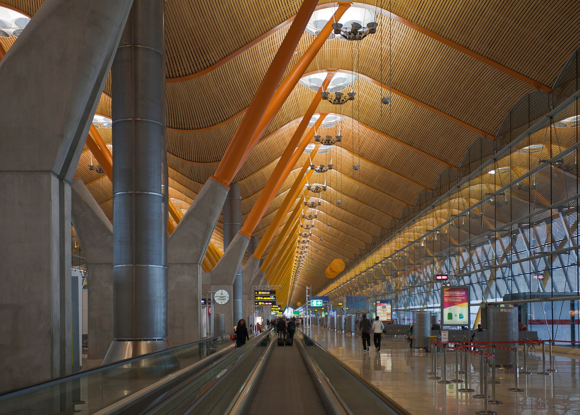 The long, wood-lined concourse of Madrid-Barajas Terminal 4 with moving walkways