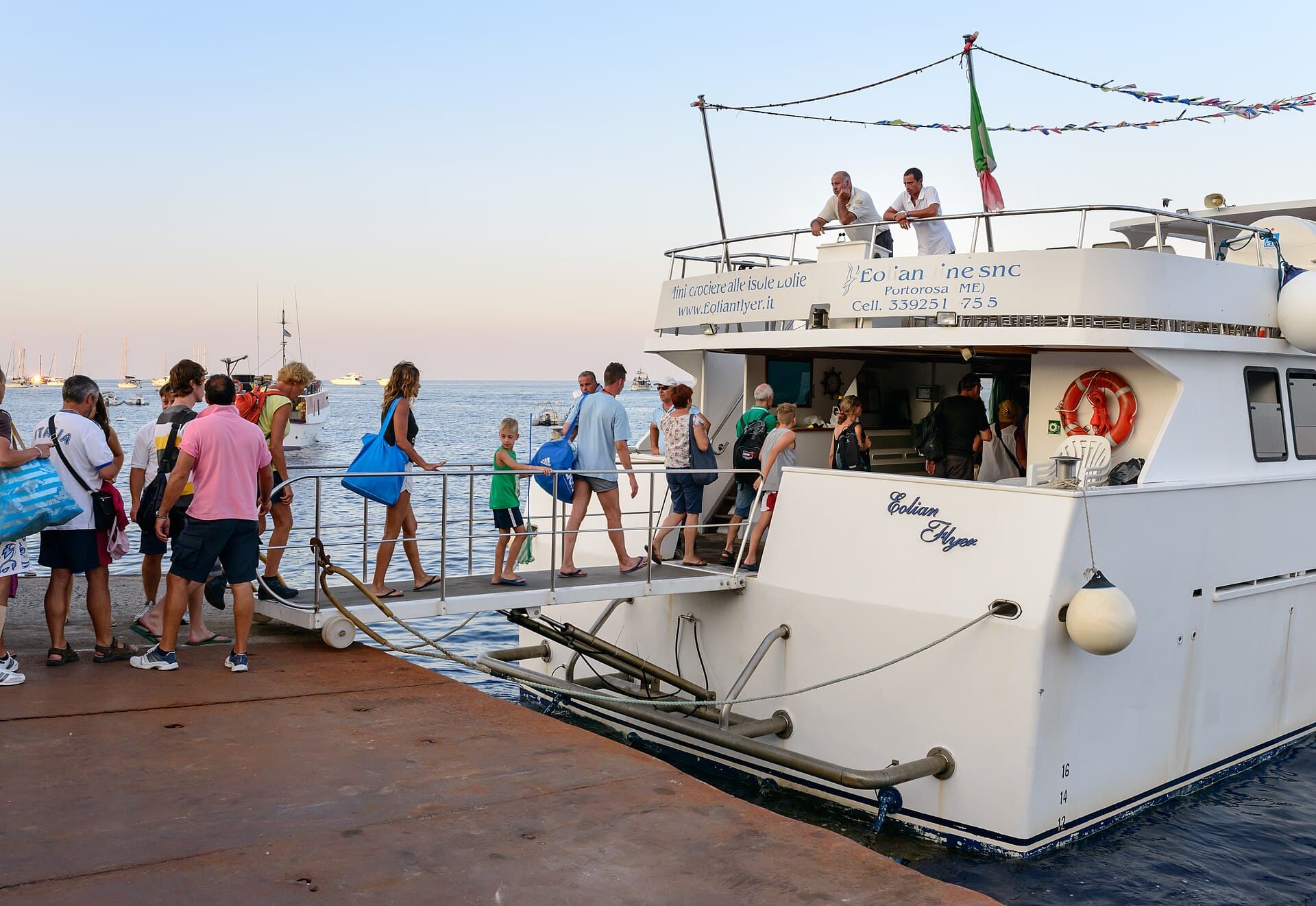 Travellers boarding a small passenger boat at a harbour on the island of Stromboli, Italy
