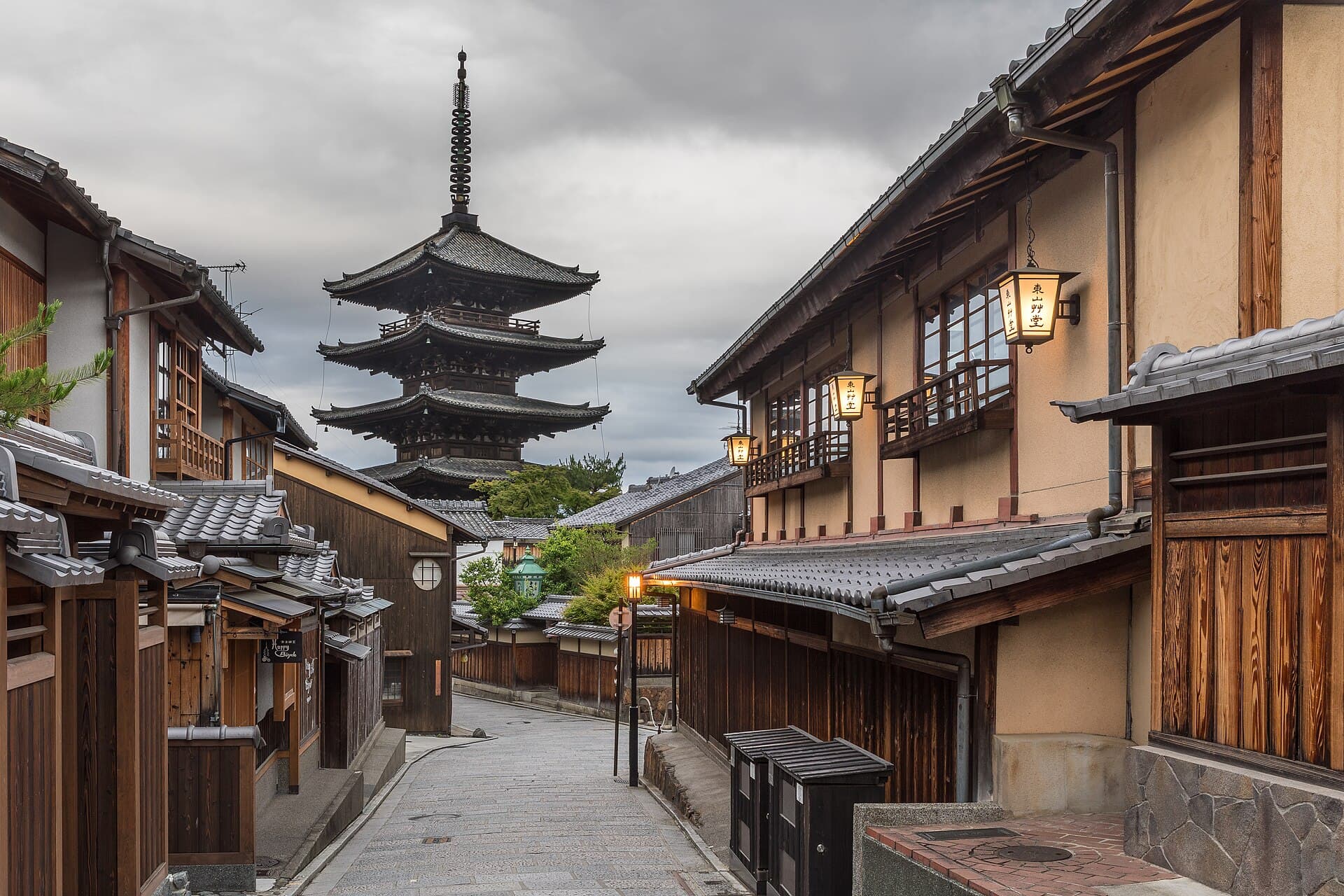 A quiet lantern-lit street in Kyoto's Higashiyama district leading to the five-storey Yasaka Pagoda